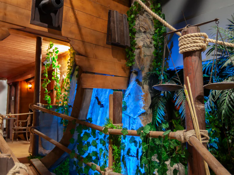 Eine Dschungelwand mit Wasserfall und Taue an Deck